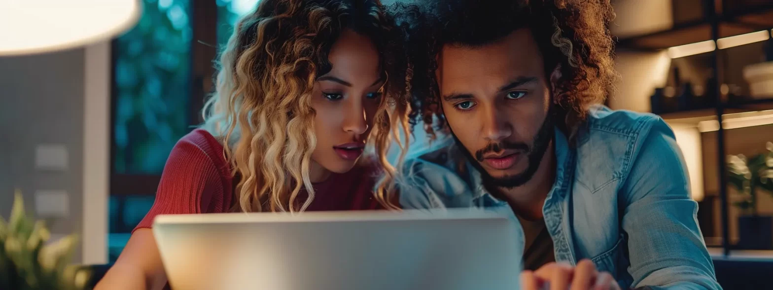 two people look at a laptop screen with a disappointed expression.